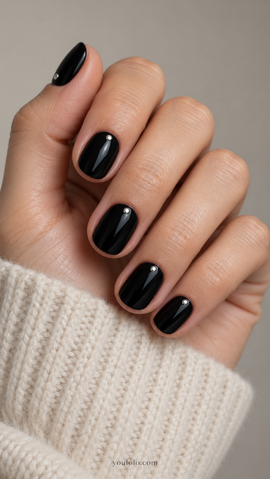 Short black nails with one tiny silver dot near each cuticle