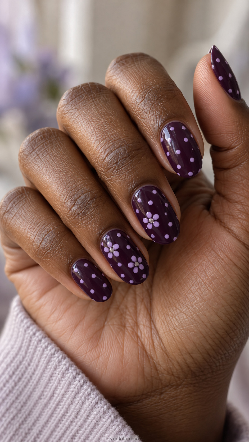 Dark aubergine nails with lilac dots and tiny flowers with silver centers.