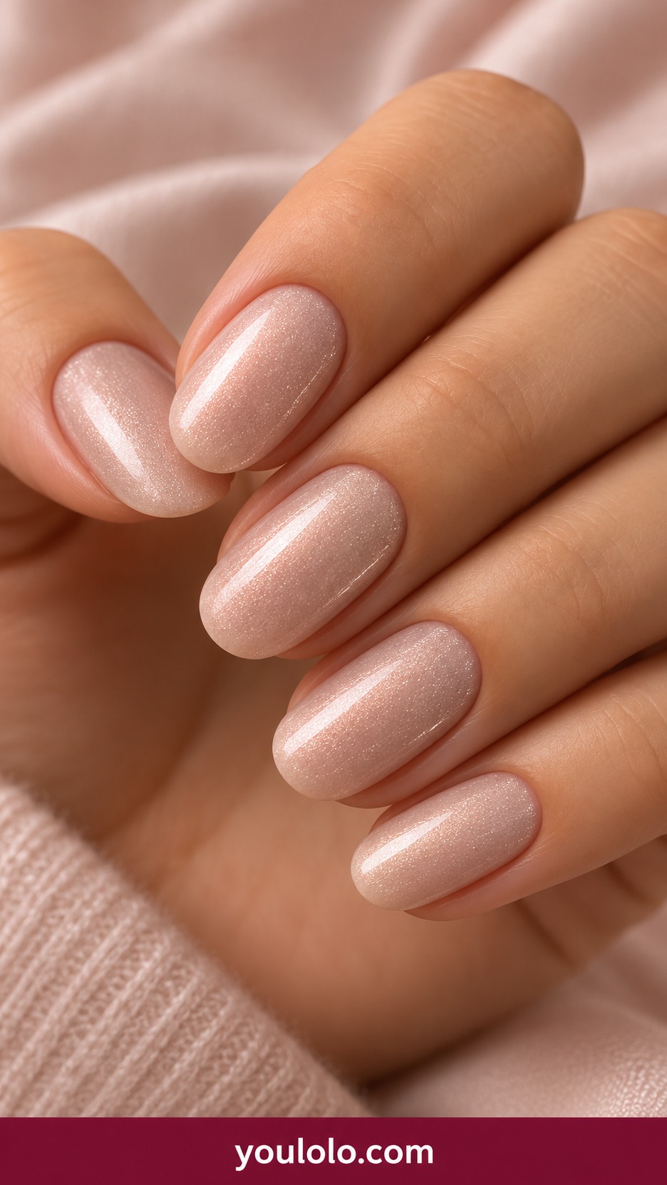 Medium oval pale champagne fine shimmer nails uniform subtle no glitter chunks on a naturally curled young adult hand