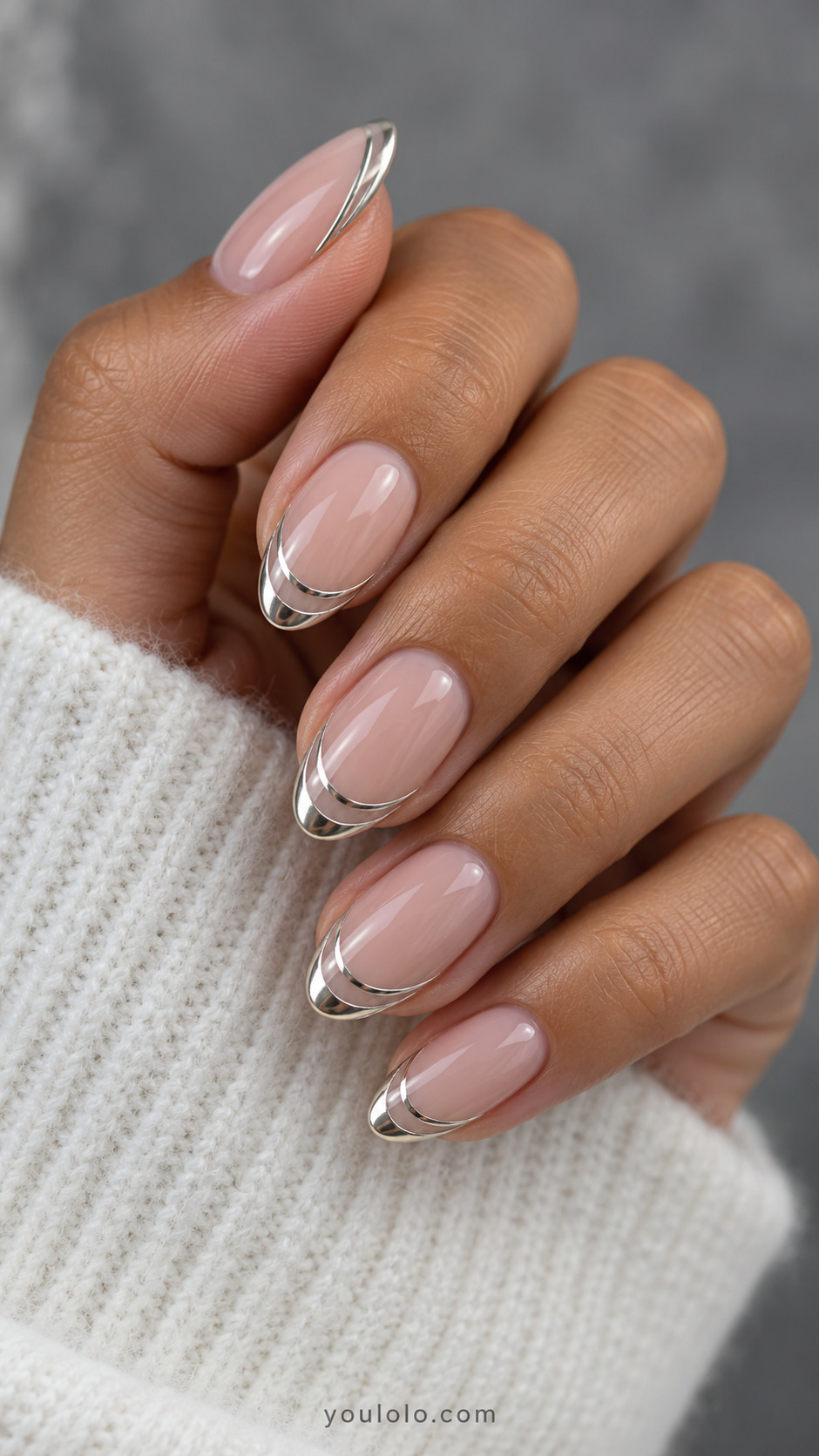 Nude almond nails with a silver French edge and a second thin arc beneath it.