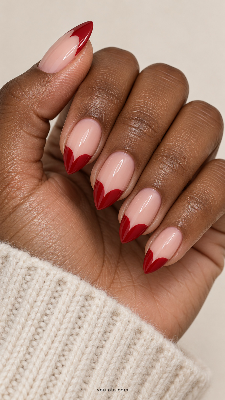medium almond blush nails, red French tips form two curved lobes meeting at pointed free edge like hearts on a naturally gathered hand