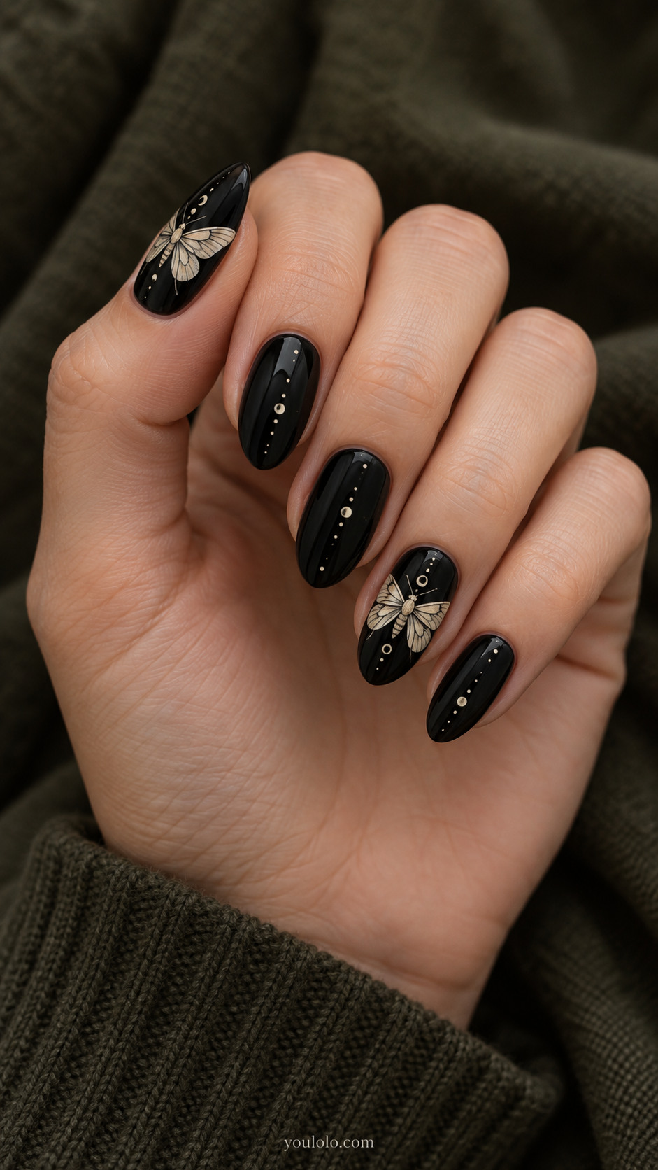 Medium almond black nails delicate ivory handpainted moth silhouettes on two nails; tiny matching scattered dots on three nails, clear wings with fine black vein detail