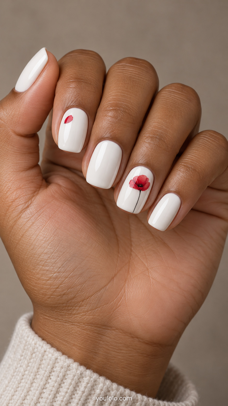 White squoval nails with a red poppy on the ring nail and a small red petal accent
