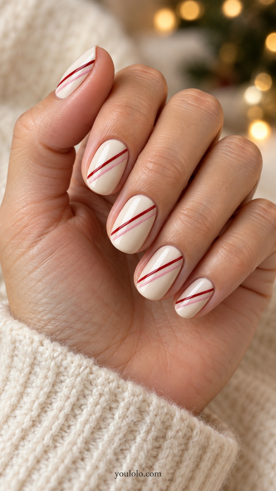 Short oval ivory nails paired thin red and blush pink diagonal lines across each nail