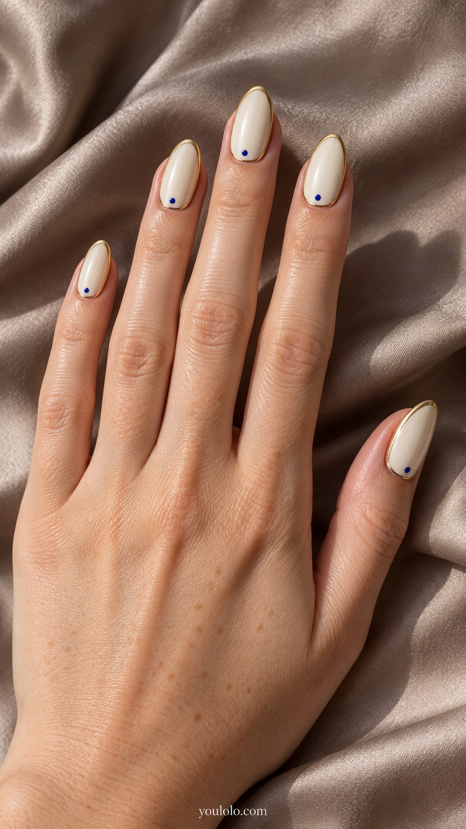 Gold-Rim Ivory Nails: medium almond ivory nails, thin flat gold rim following border with tiny cobalt dot accent