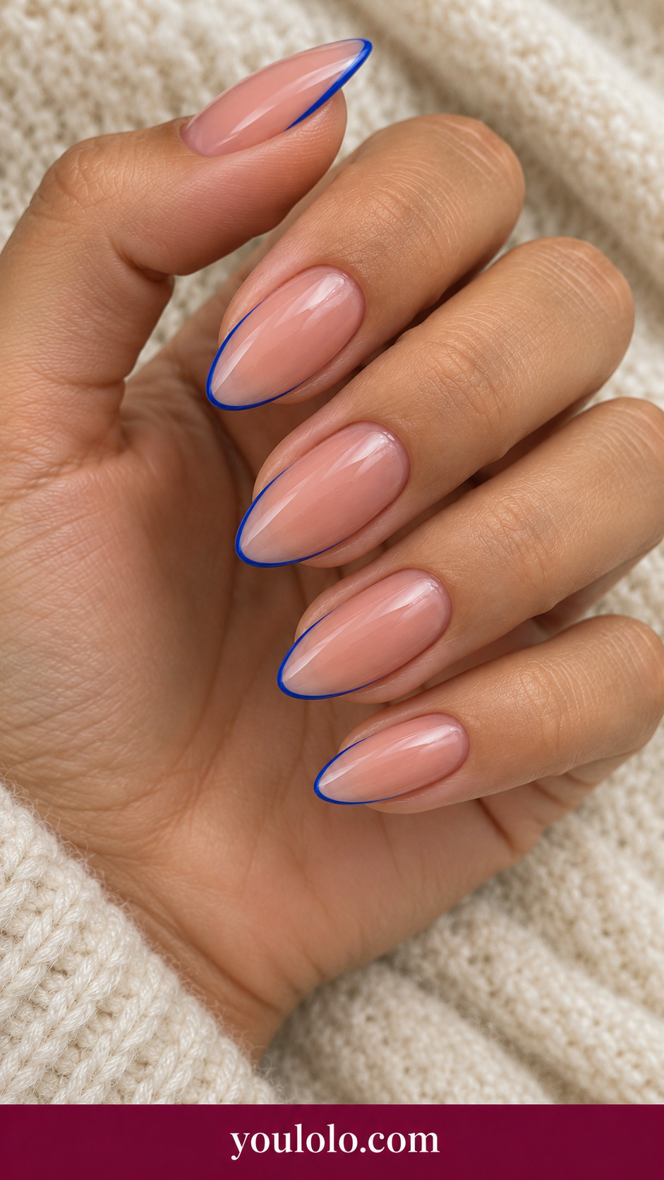 medium almond sheer pink press-on nails very fine cobalt blue perimeter outline, clear center on a naturally posed adult female hand