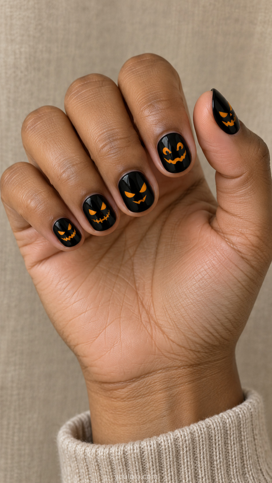 Short round glossy black nails amber orange tiny jack-o-lantern eyes and mouths floating on black, no full pumpkins, different clean mischievous face each finger