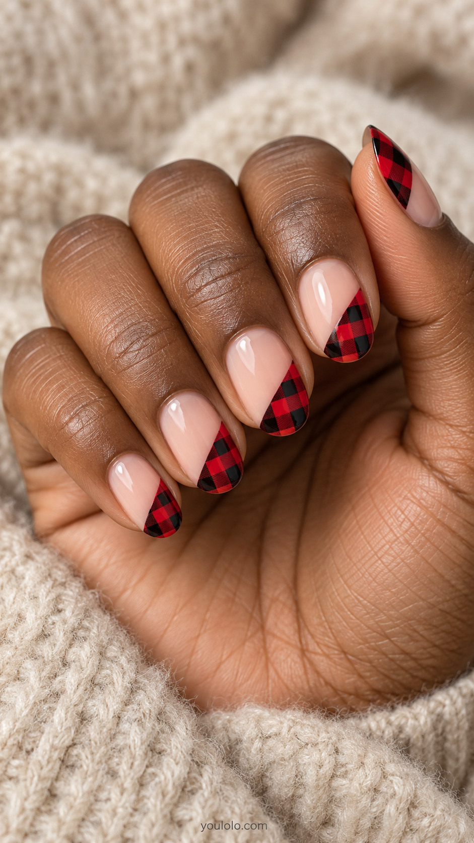 Nude oval nails with diagonal red-and-black checked corners