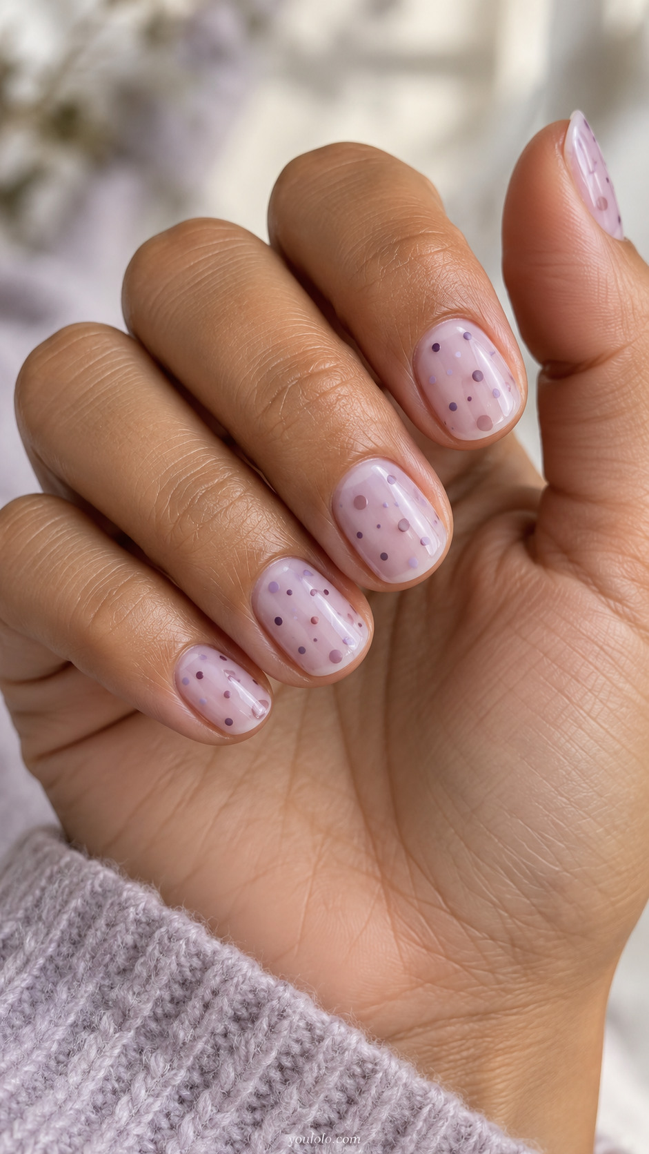 Short sheer lilac nails with berry and mauve confetti dots.