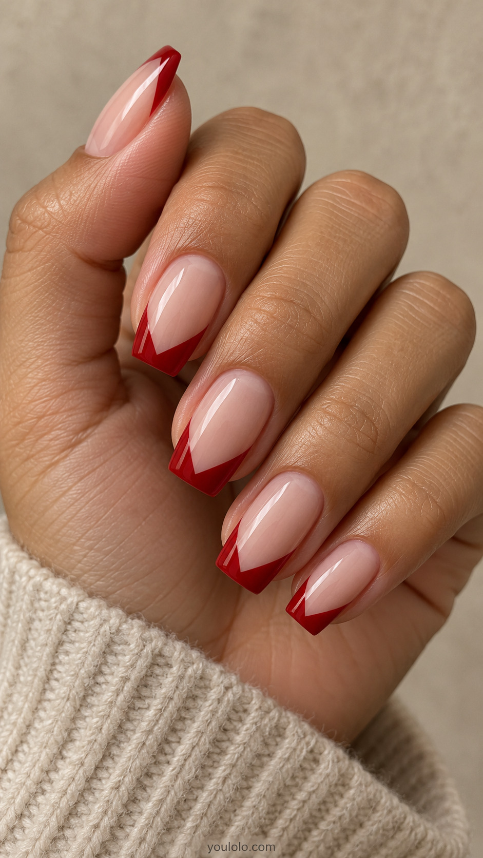 medium tapered-square nude nails, crisp red V-shaped French free-edge tips on a naturally gathered hand