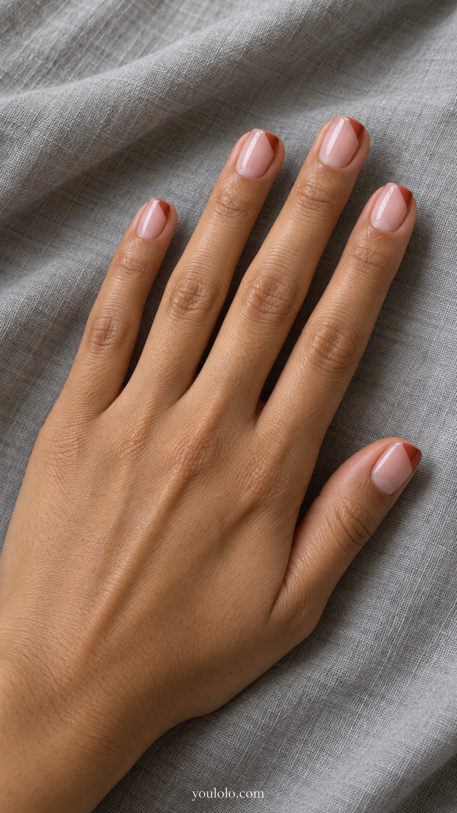 Short squoval nails sheer pale pink with small solid rust diagonal corner at outer tip each nail