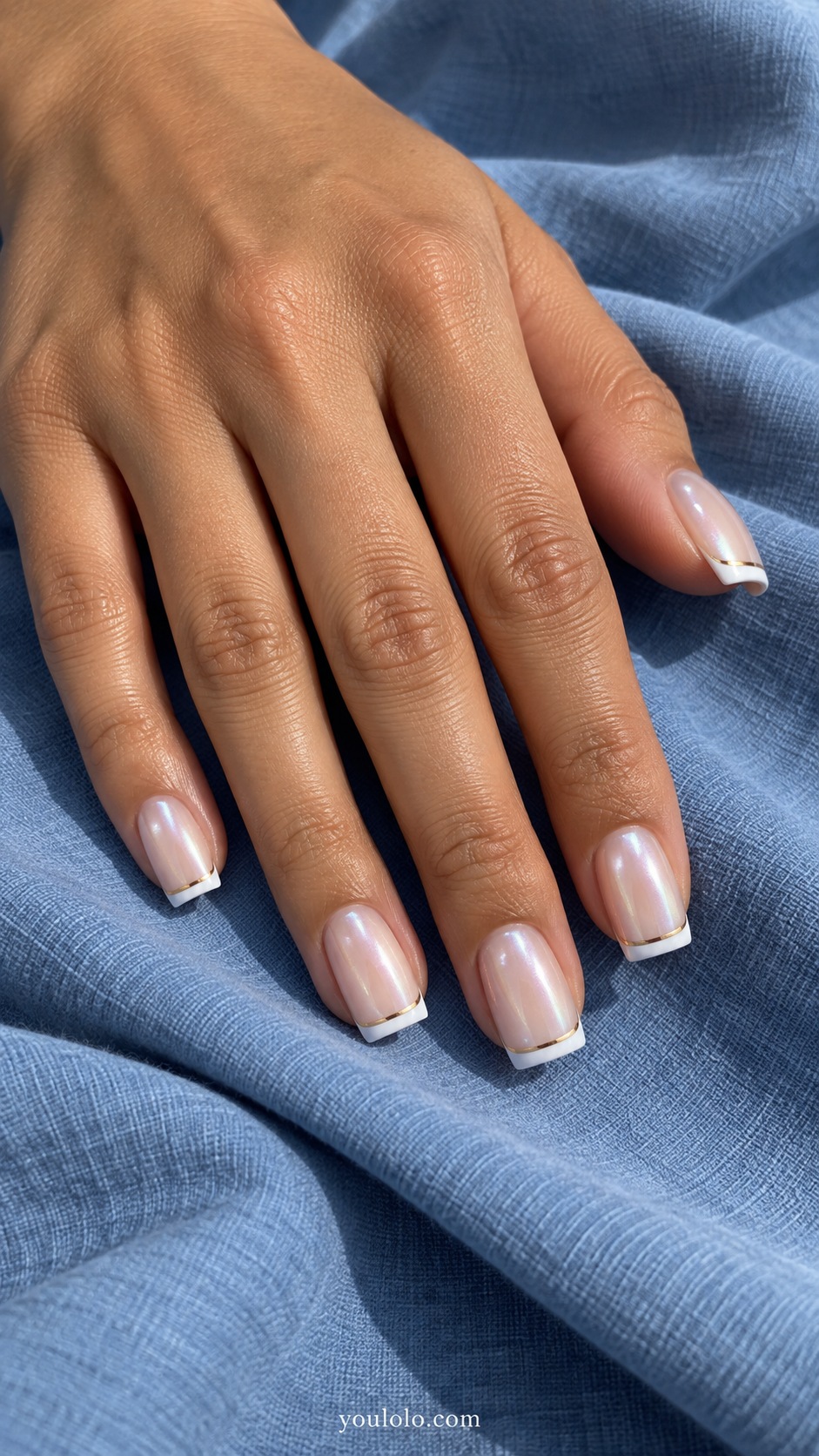 Medium square nails sheer beige pearl glazed base, thin white French edge with a separate very thin champagne metallic arc just below it