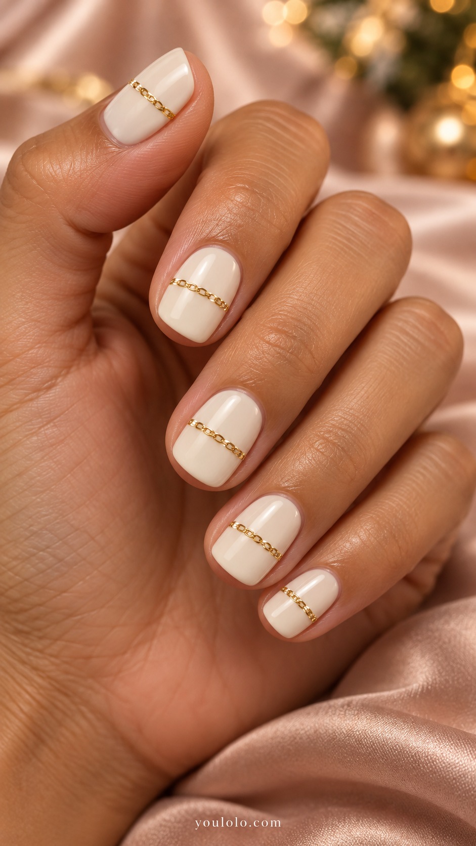 Short squoval ivory nails one fine gold chain-like transverse painted band across each nail