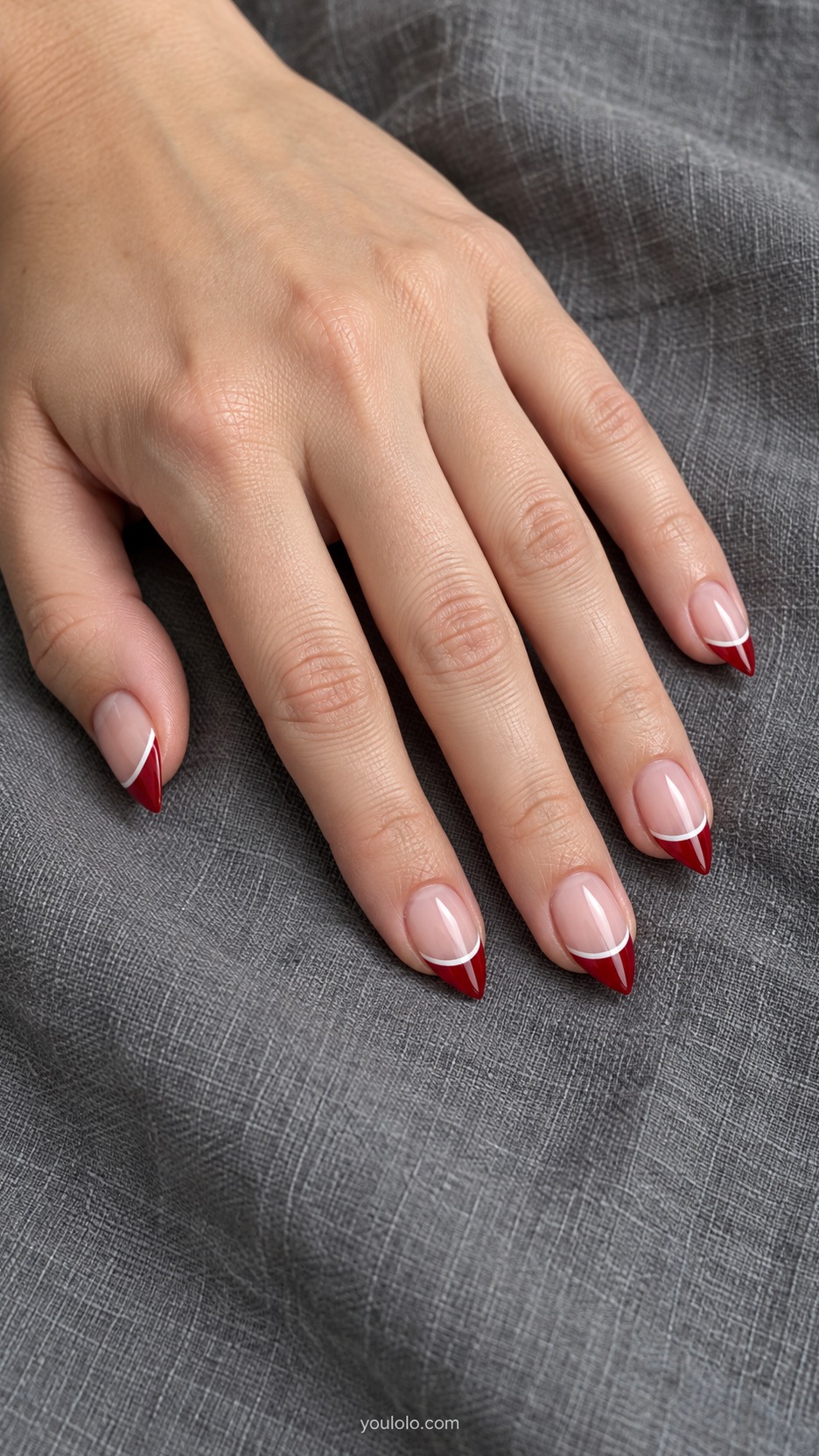Short Stiletto French Nails: Cherry Pinstripe French manicure on a naturally posed hand