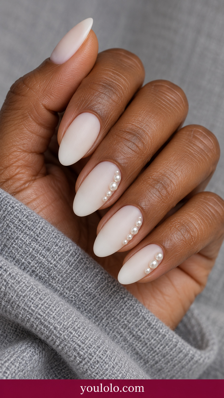 medium almond warm ivory nails two accents with small spaced low-profile ivory pearl beads along one side, others plain on a naturally relaxed adult hand