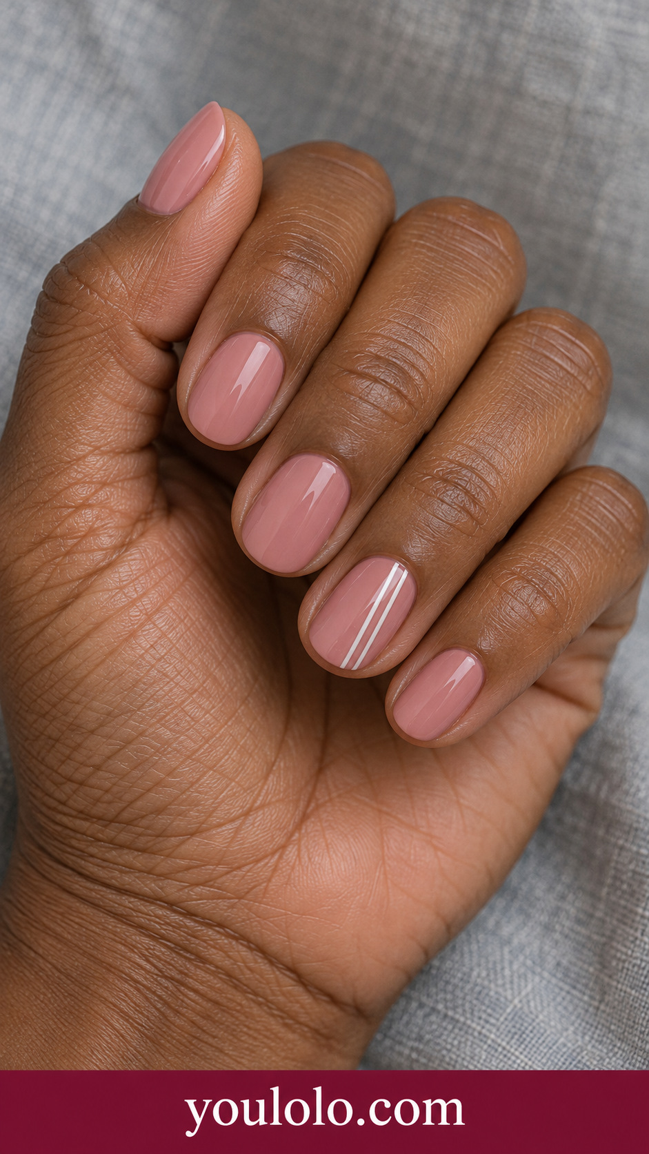 White Twin Rails: short oval dusty rose cream nails two thin parallel white vertical lines on ring nail only on a naturally posed adult hand