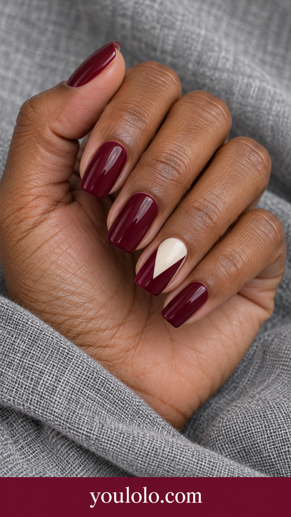 Maroon Cream Ribbon Fold: medium soft square maroon nails one accent flat painted ivory folded ribbon geometric V shape, no bow on a naturally posed adult hand