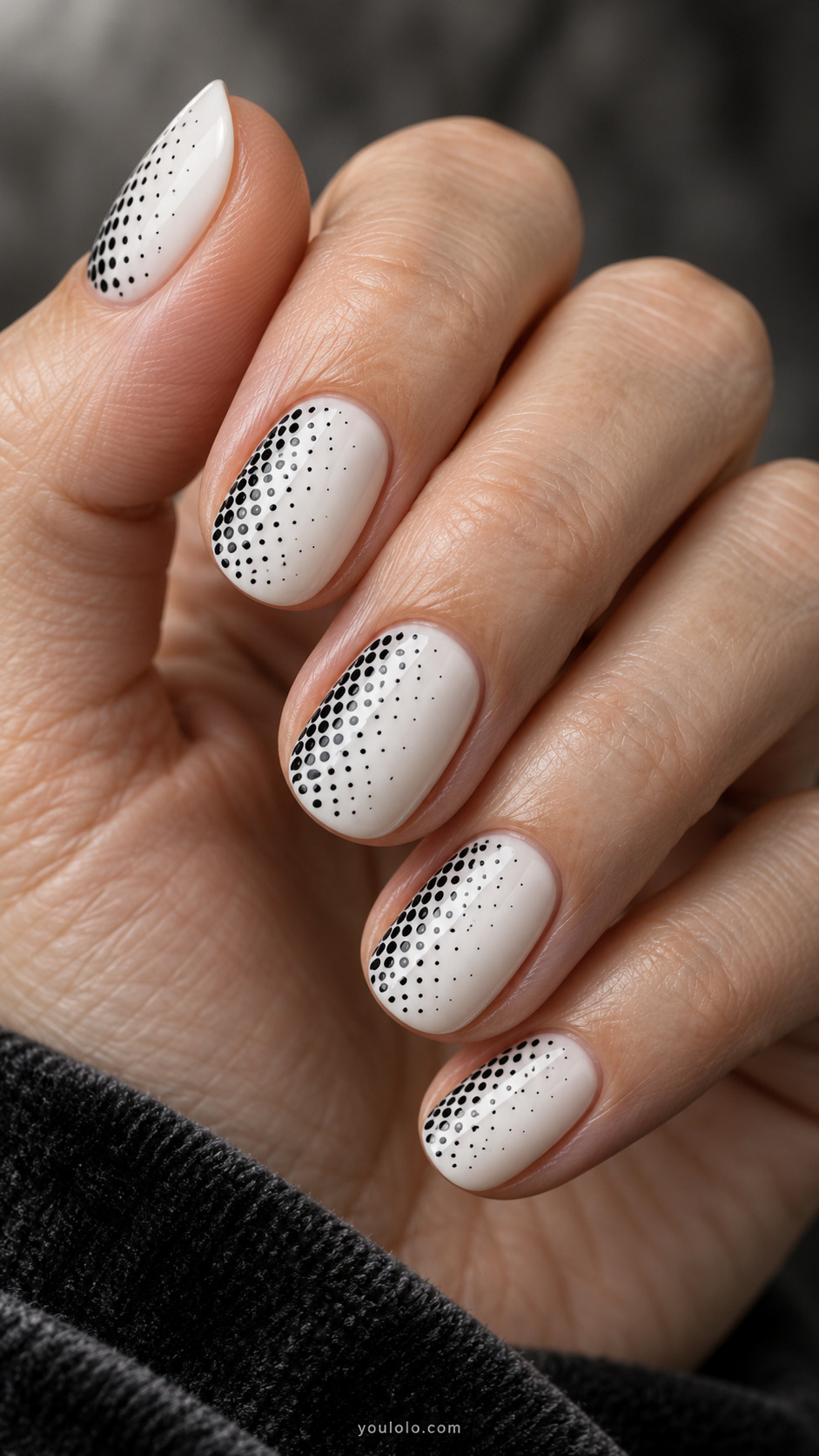 Short oval white nails with tiny black dots extremely dense at one sidewall fading sparsely toward opposite sidewall, sideways halftone gradient
