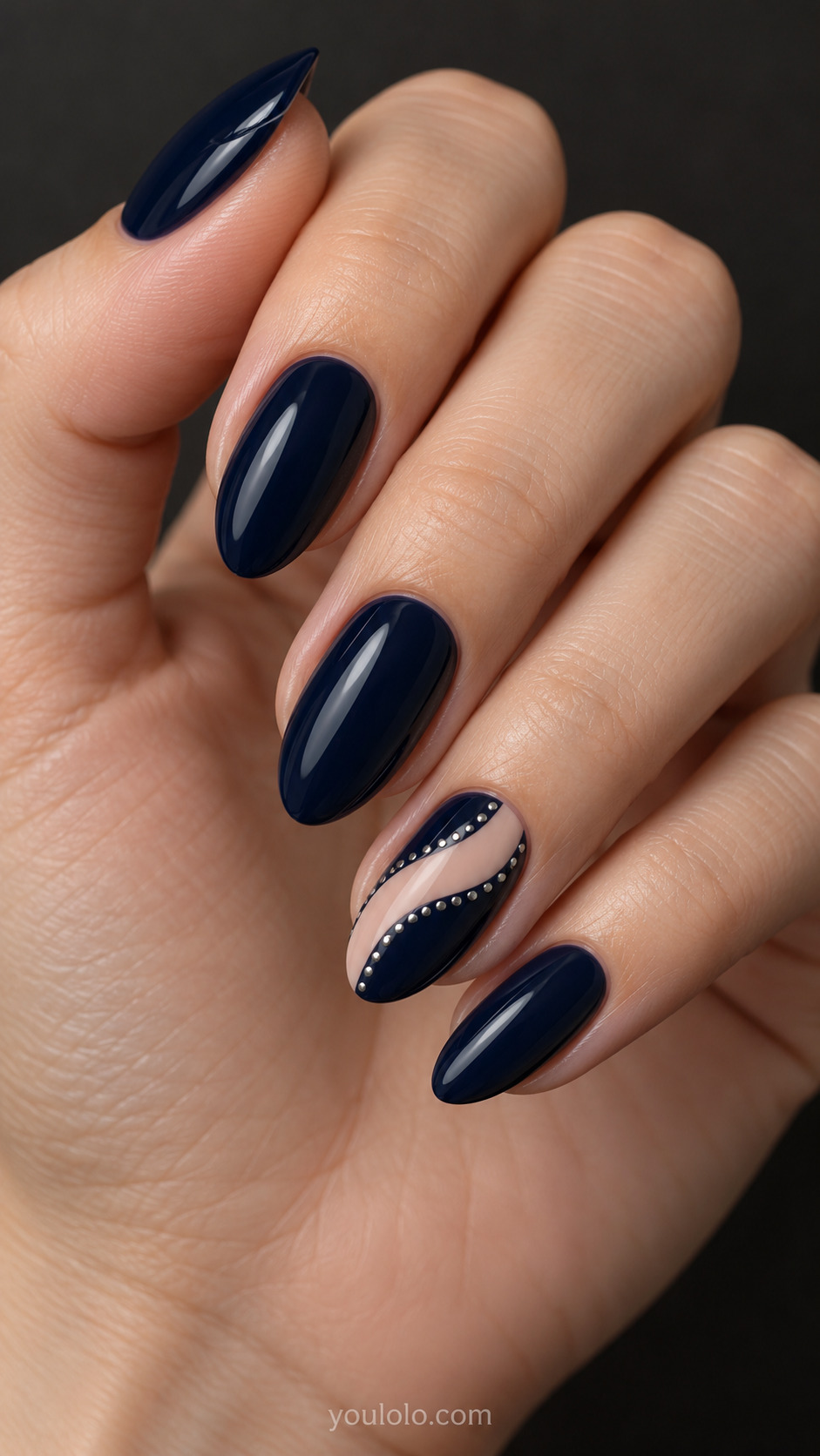 Nude Ribbon Through Midnight on a naturally posed hand, showing dark blue polish and detailed nail art