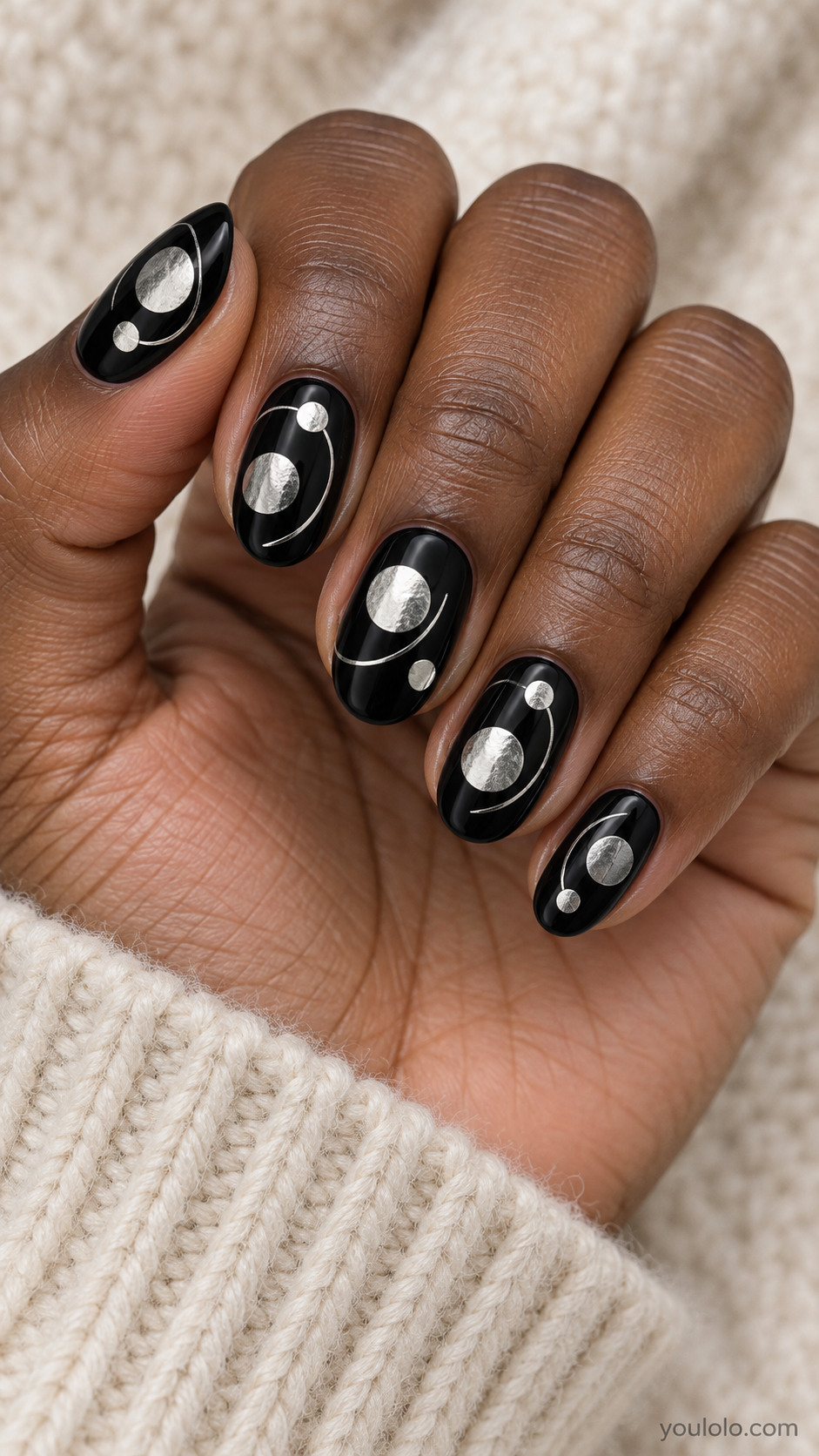 Medium oval black nails asymmetrical flat silver circular discs in two sizes with a single thin silver orbit arc around each, elegant abstract circles no stars no moon crescents