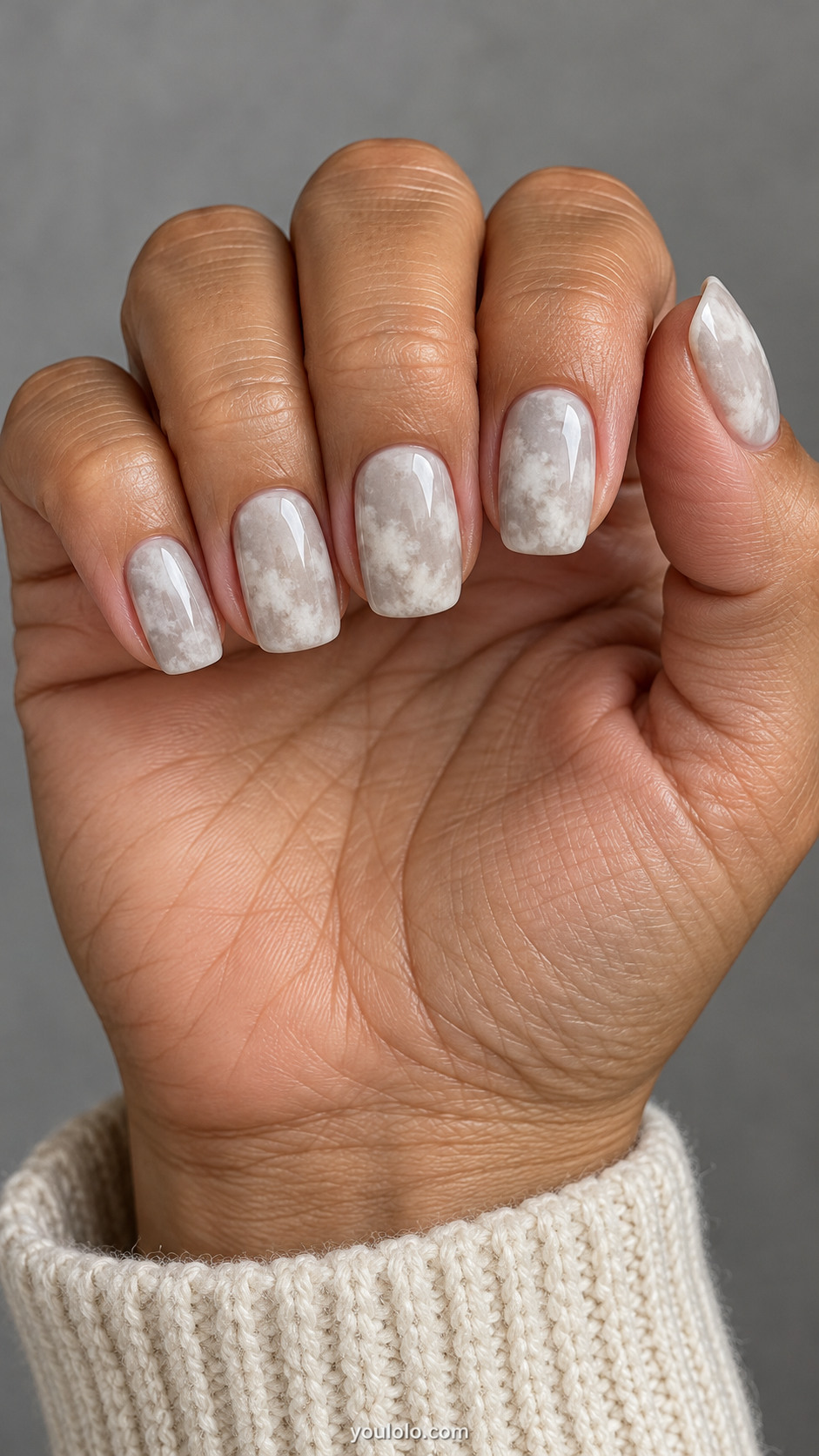 Medium squoval nails: milky warm gray nails with softly mottled off-white stonewashed cloud patches, no sharp veins.