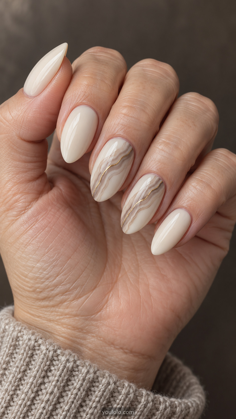 Medium almond ivory nails with pale taupe agate curves and a fine gold vein on two accents