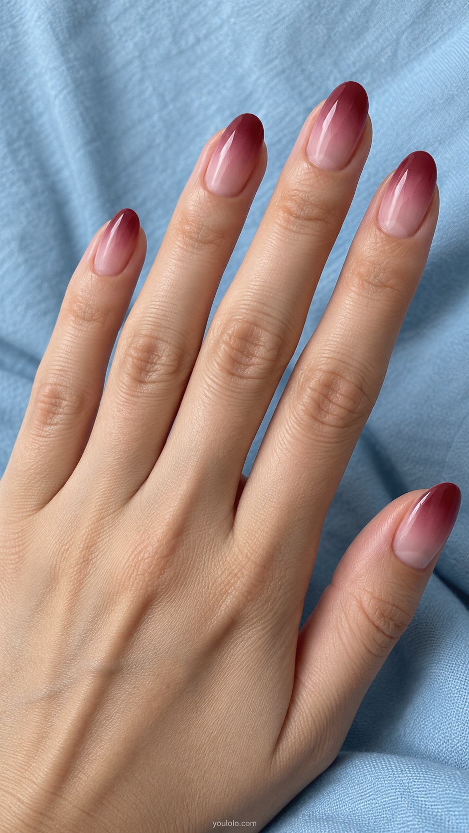 Medium oval nails smooth gradient from translucent soft pink at cuticle to dusty wine red tips
