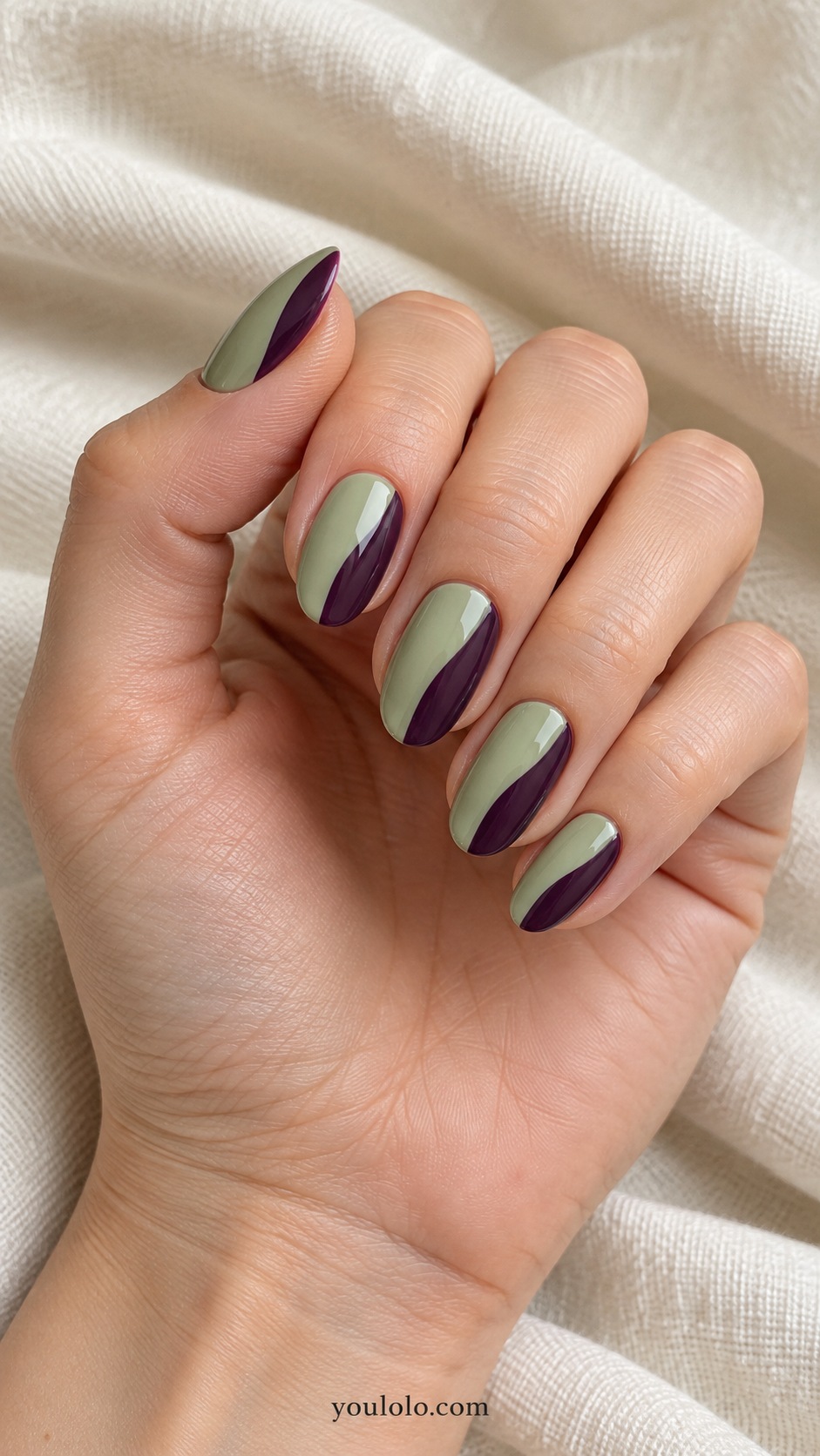Medium oval nails soft pistachio base one broad dark plum curved side panel each nail