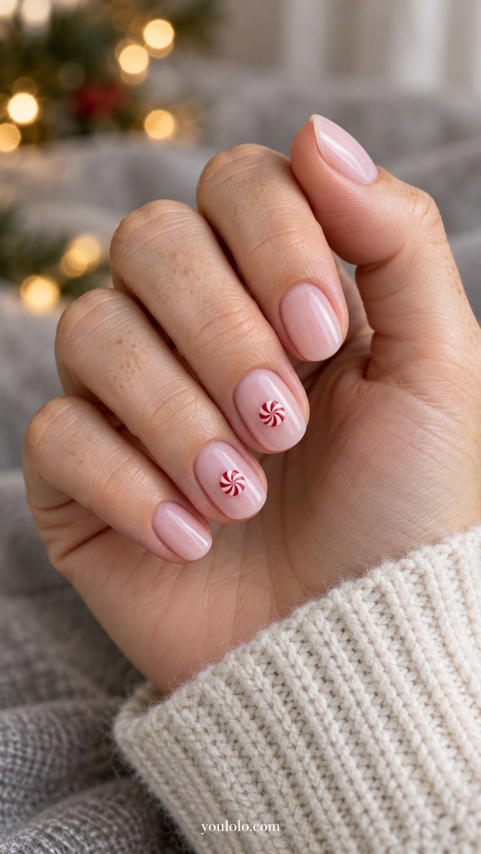Short round milky pink nails one tiny flat red white circular peppermint motif on each ring and middle nail