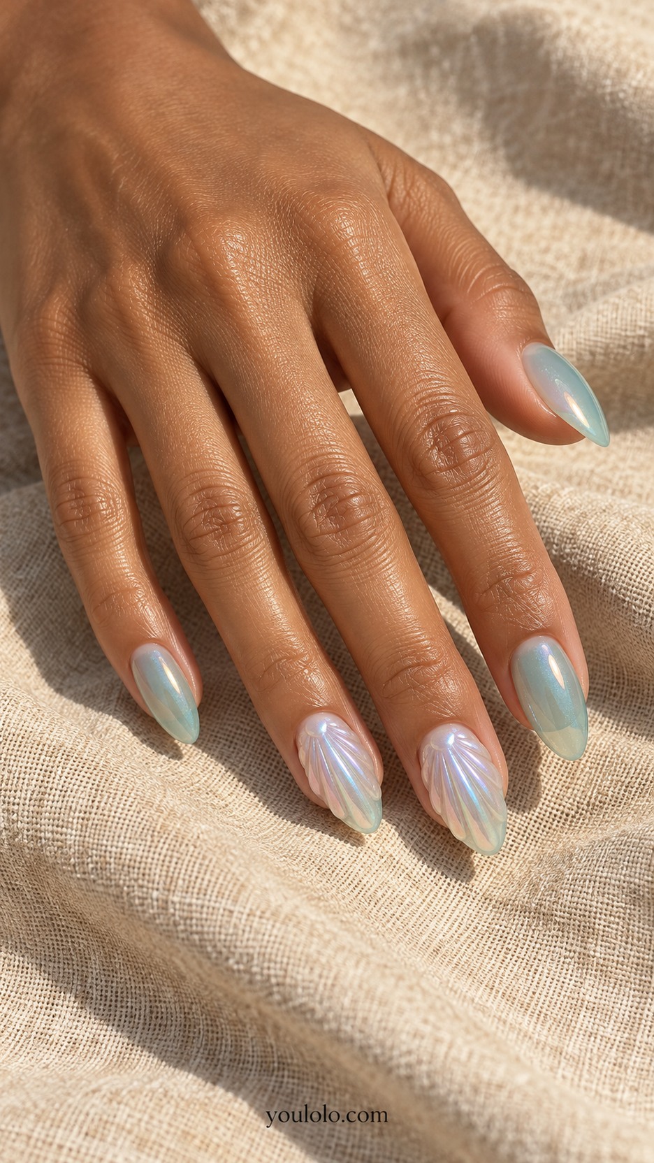 Opalescent Glass-Shell Nails — Medium almond nails, translucent seafoam and opal, ring and middle nails have low sculpted fan-shaped seashell ridges with subtle lavender iridescent highlights, other nails clear seafoam glaze, no pearls