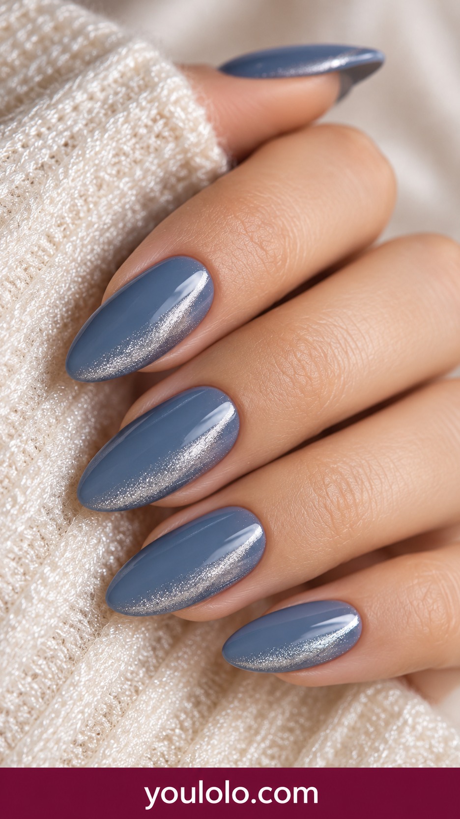 Medium almond dusty blue nails with a narrow silver magnetic side sweep on a naturally curled young adult hand