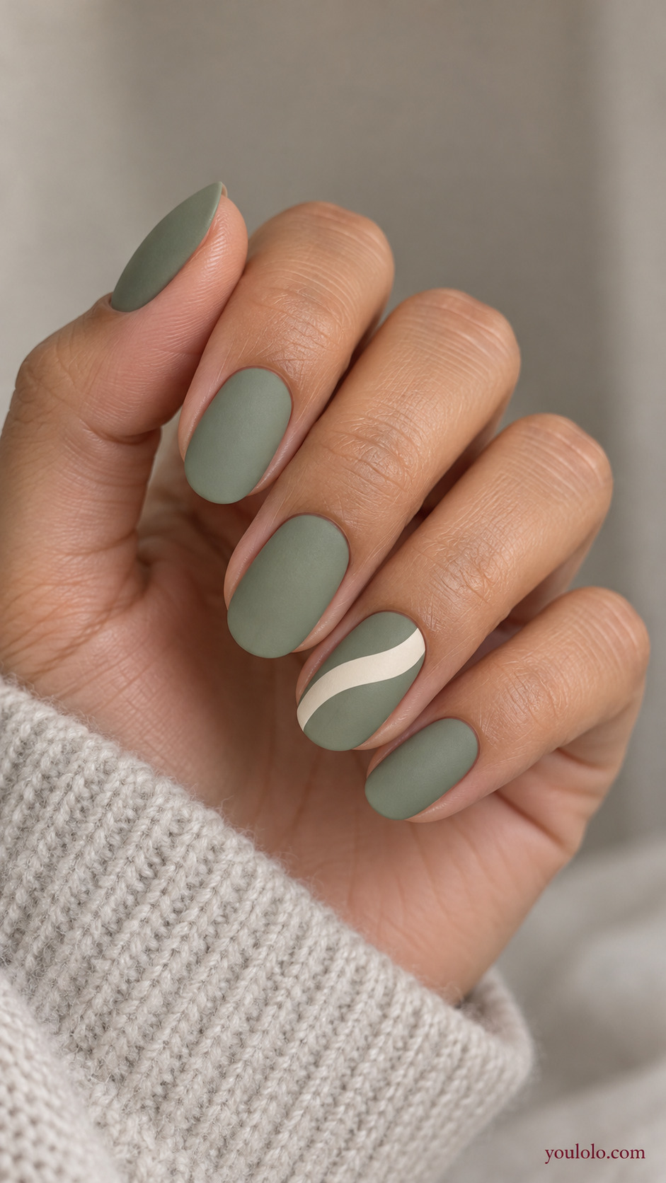 A Single Sweeping White Ribbon on a softly gathered feminine hand with a matte green manicure