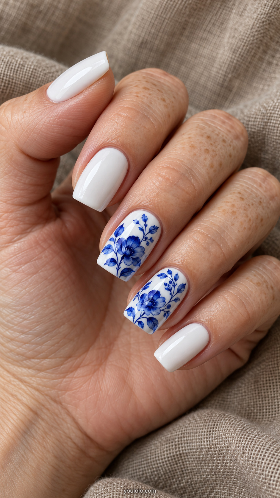 White square nails with fine royal blue floral painting on two accent nails