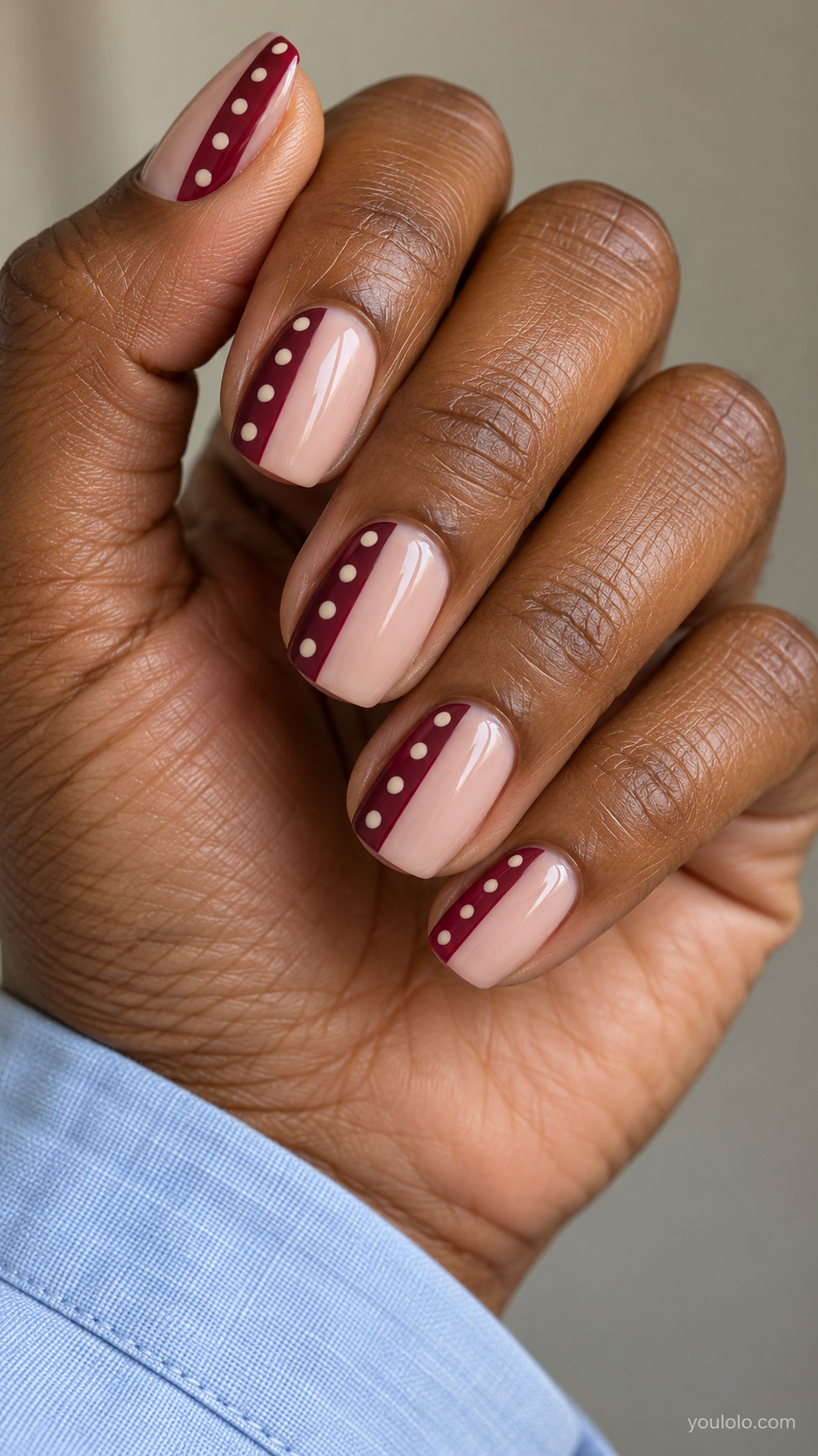 Medium squoval nails, vertical burgundy side panel occupying one third nail, cream tiny polka dots in that panel, two thirds translucent nude.