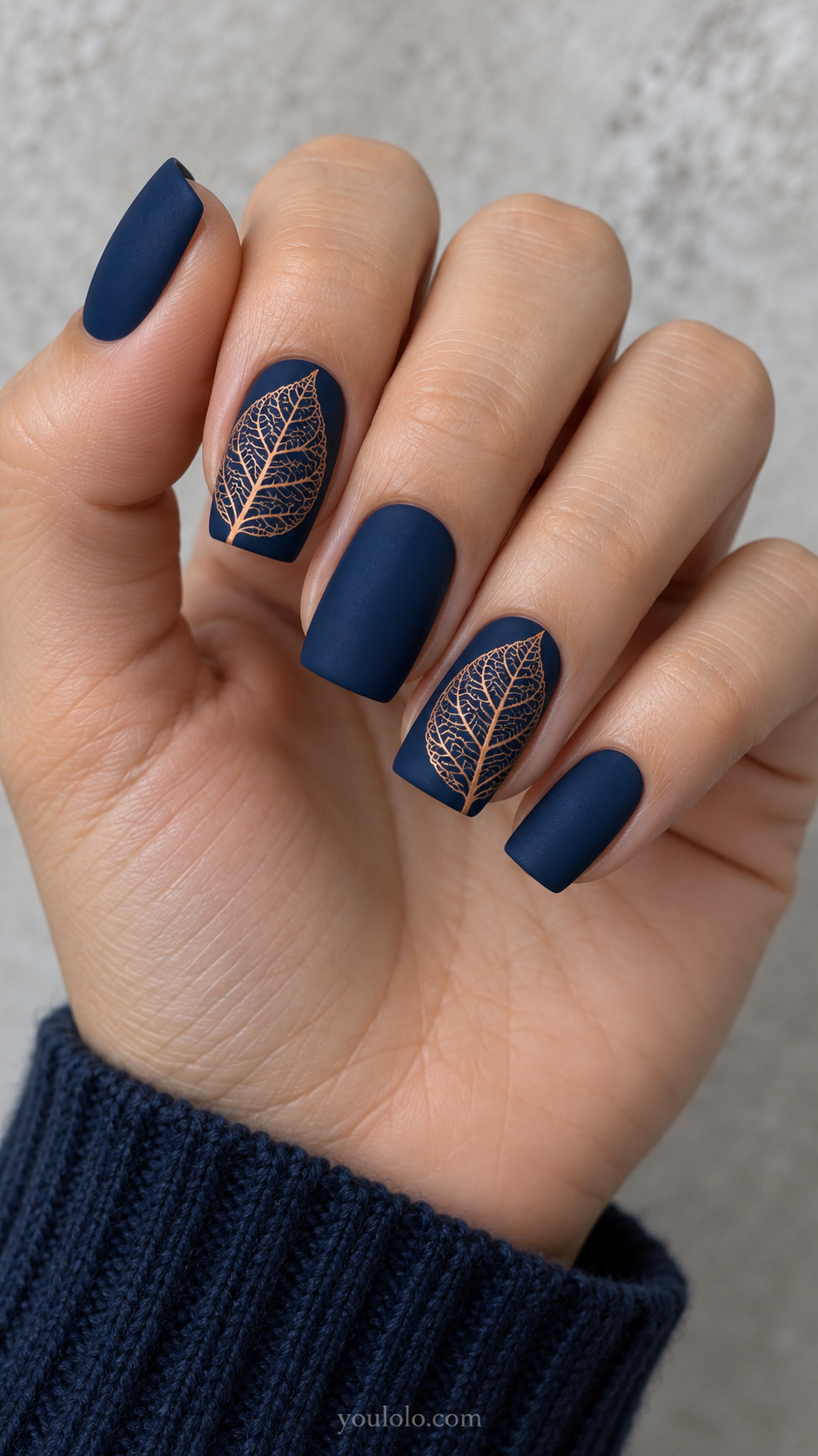 Medium square nails with matte navy nails, index and ring carry large flat copper painted skeleton leaf shapes with delicate branching veins and open navy gaps; no raised metal.