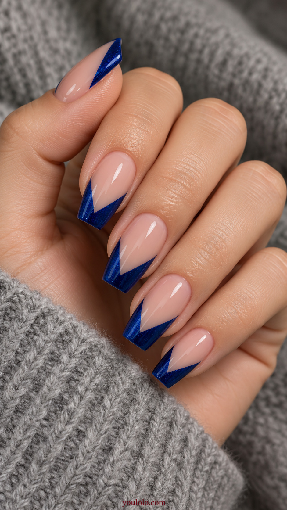 Sapphire V Tips on Soft Coffin Nails on a softly gathered feminine hand with detailed sapphire blue manicure