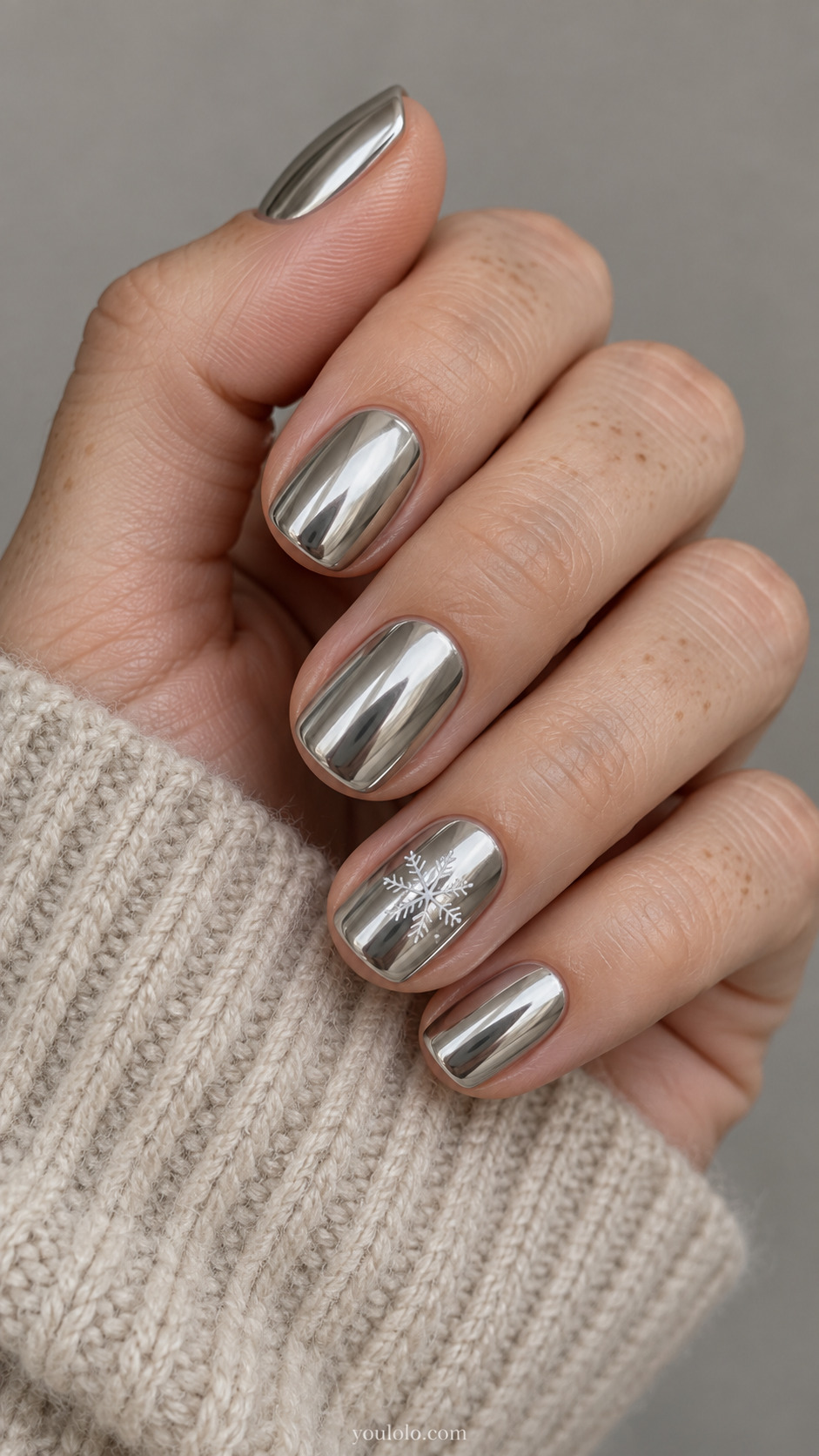 Silver mirror chrome on short squoval nails, with one fine white snowflake accent.