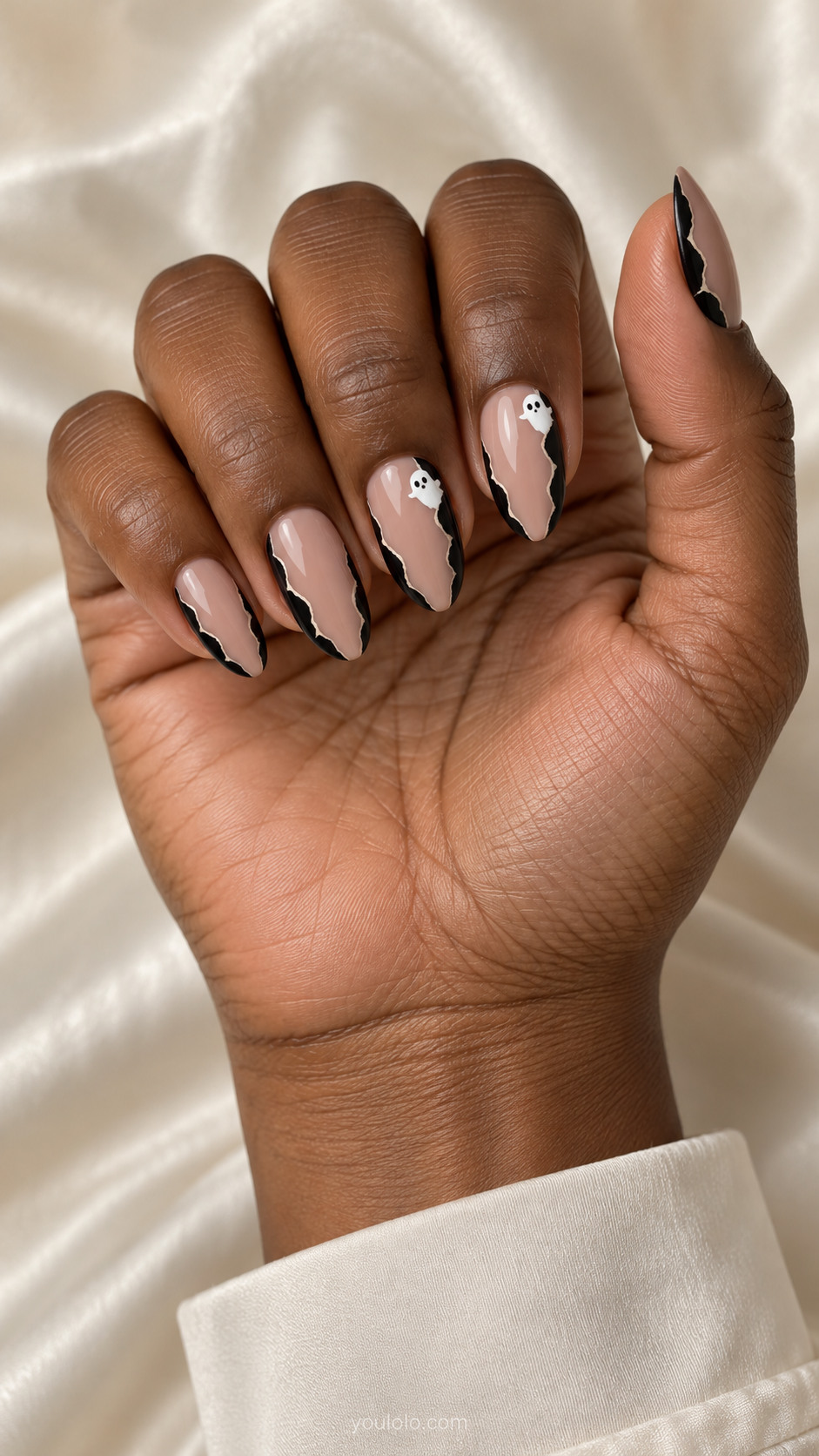 Medium almond nude nails jagged torn-paper black borders at both sidewalls, slim beige center gap with one tiny white ghost near upper edge on two nails