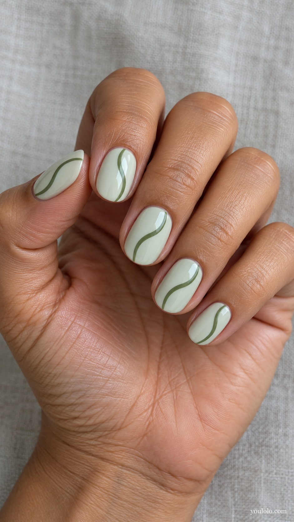 Short oval nails pale muted mint cream with a single thin moss green S curve per nail