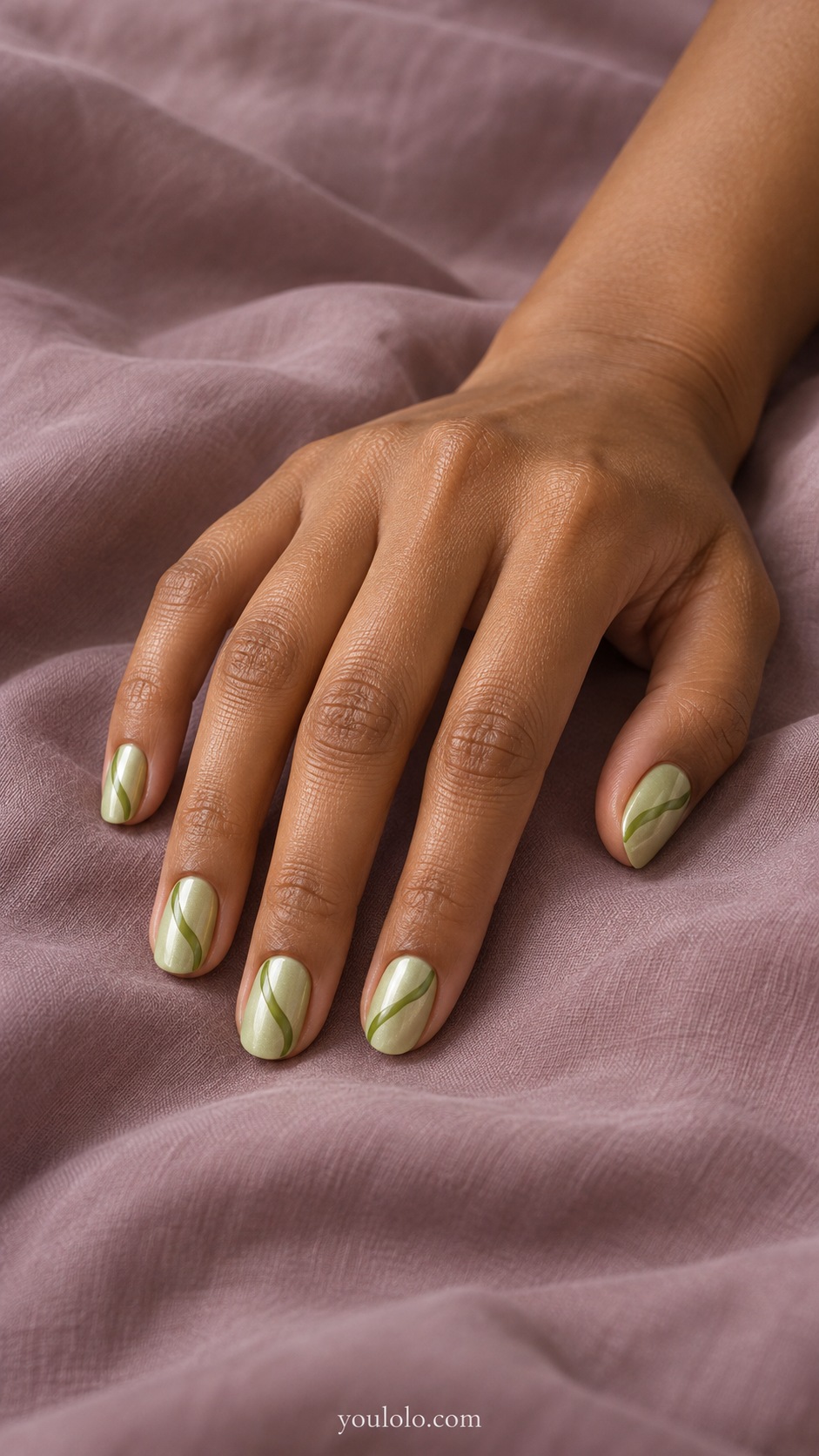 Short oval pale matcha pearl base one slim flowing darker matcha green ribbon across each nail