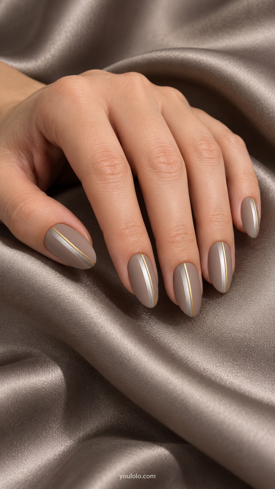 Brushed Metal Stripes: medium almond matte taupe nails, narrow brushed silver vertical stripe beside fine gold line
