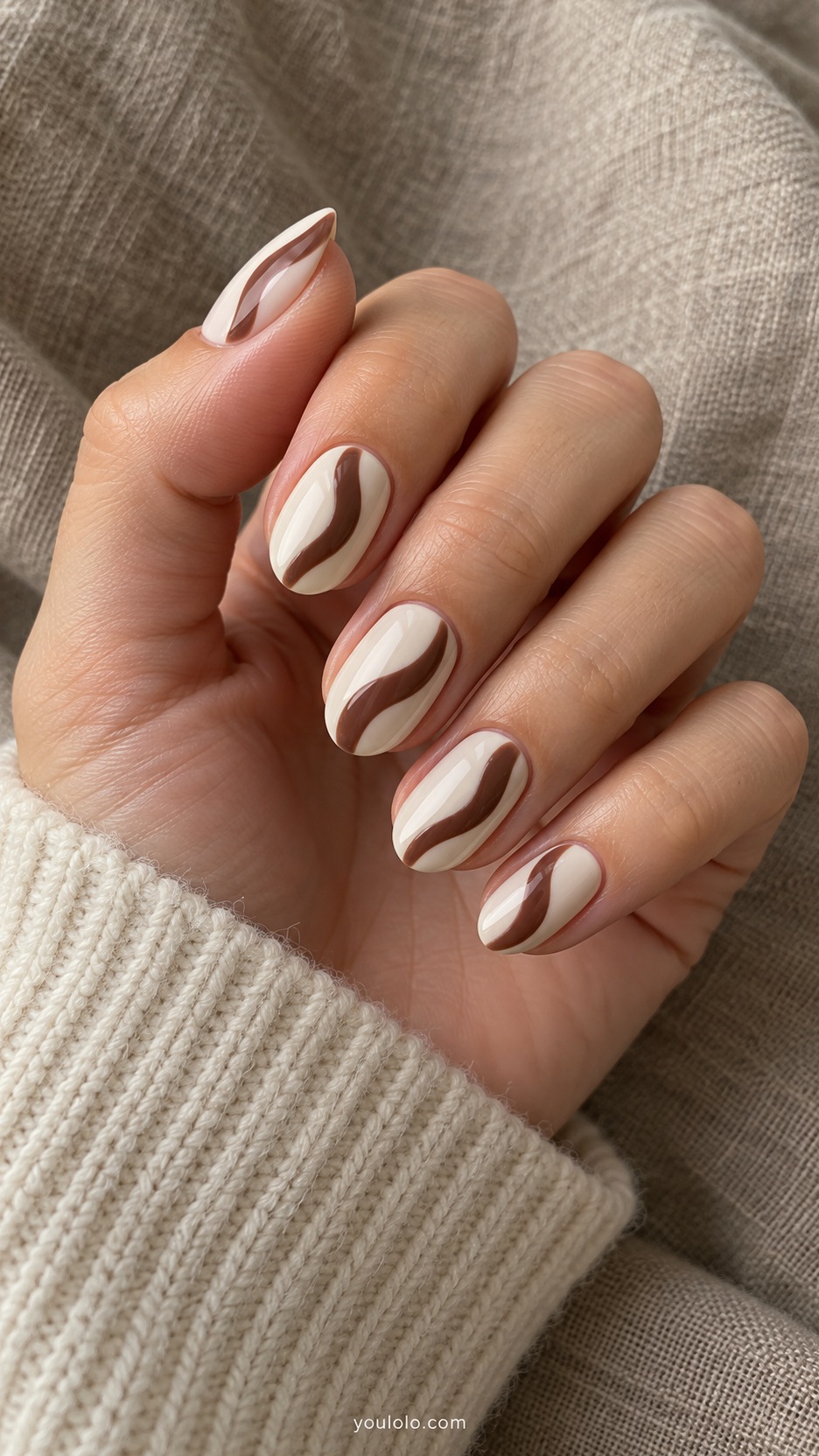 Short Almond Nail Designs: Cream and Cocoa Waves manicure on a naturally posed hand