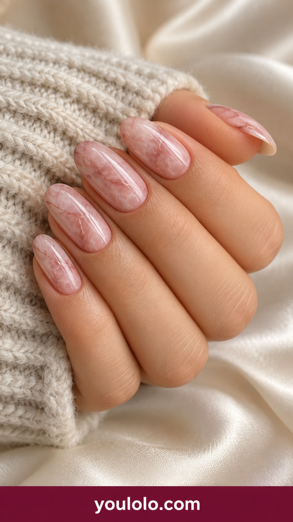 Medium squoval pale rose quartz marble nails with translucent cloudy pink veining and one fine rose gold thread accent on a naturally curled young adult hand