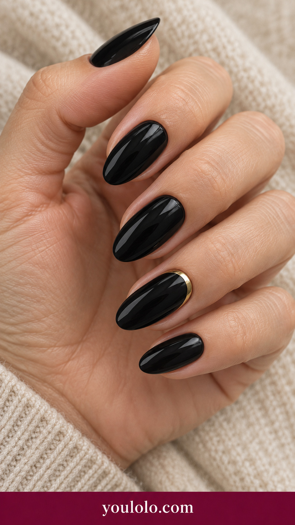 medium almond black glossy press-on nails slim metallic gold half moon along base of ring nail only, others plain black on a naturally posed adult female hand