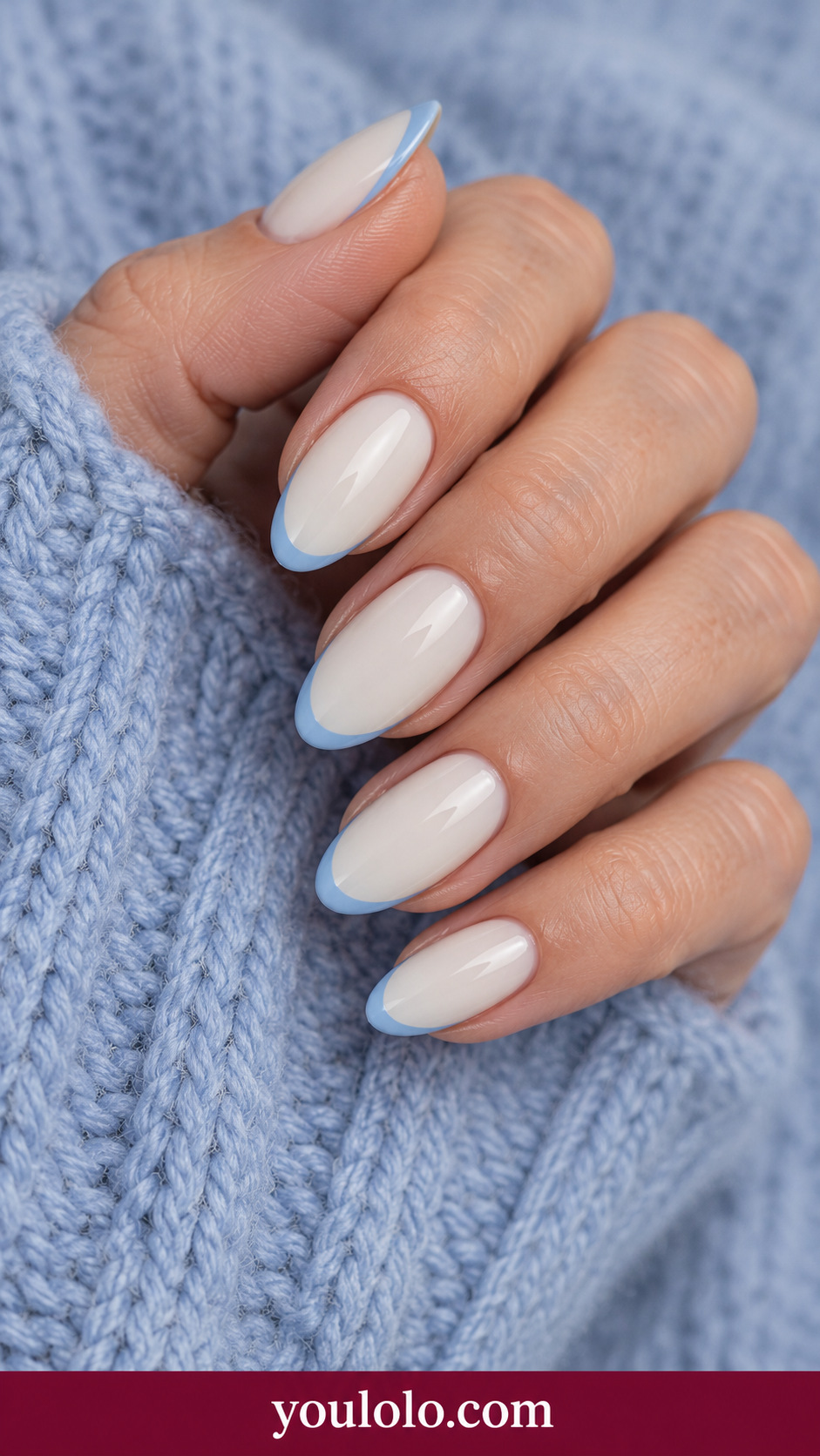 medium oval plain glossy ivory nails fine dusty blue narrow tip border on each nail, no florals on a naturally relaxed adult hand