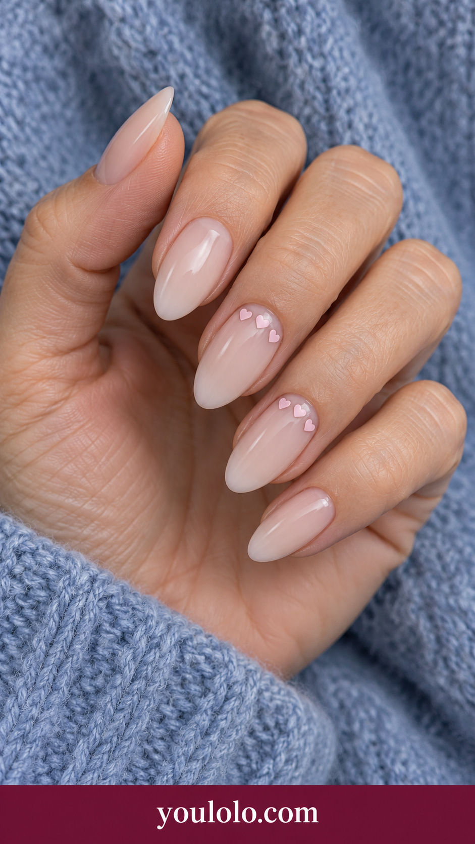 Heart Cuticle Chain: medium almond sheer beige nails three tiny flat pale pink hearts along curved base on two nails on a naturally posed adult hand