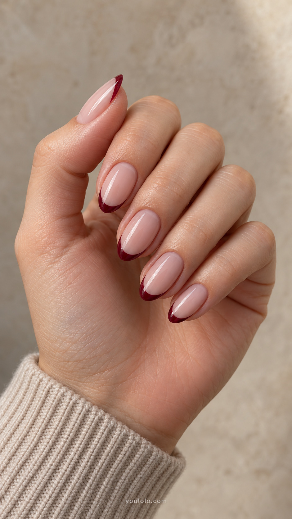 Medium oval nails with pink beige bases and thin wine red French tips.