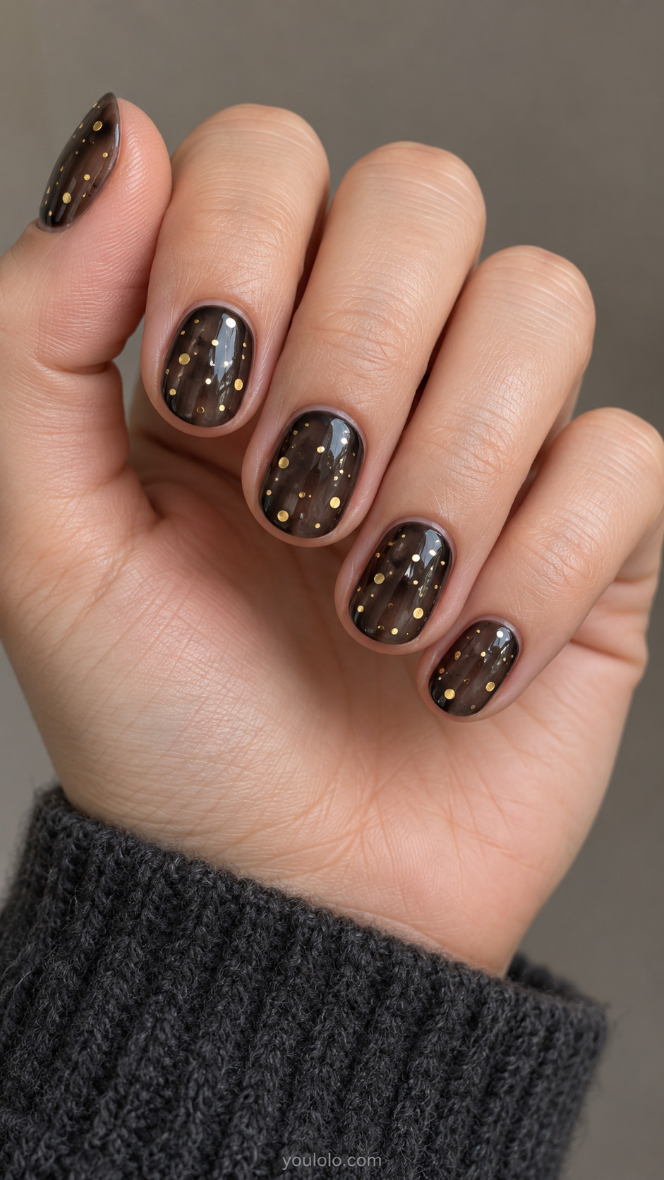 Smoky black jelly nails with sparse round gold confetti pieces