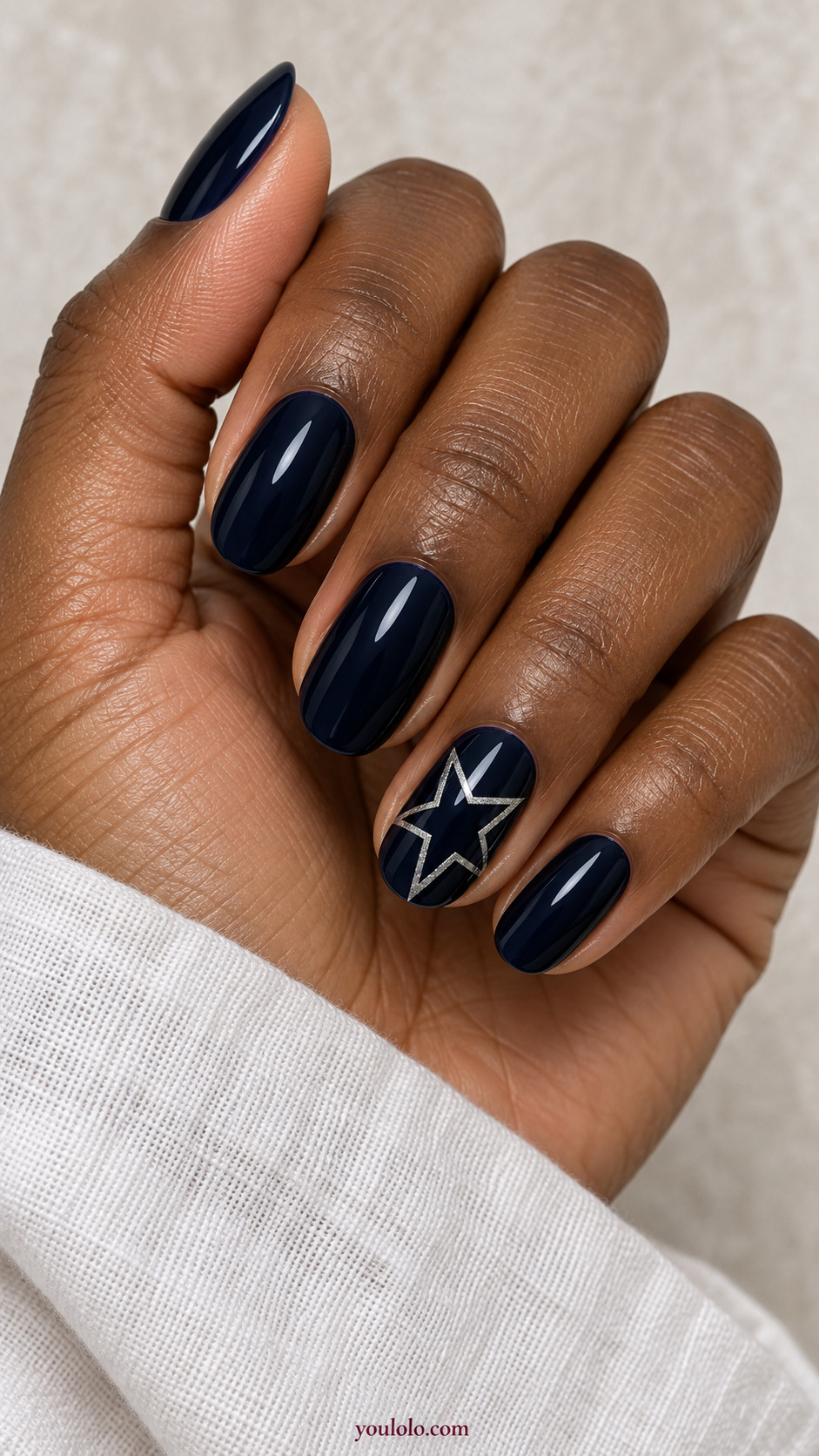 One Oversized Outline Star on a naturally posed hand, showing dark blue polish and detailed nail art