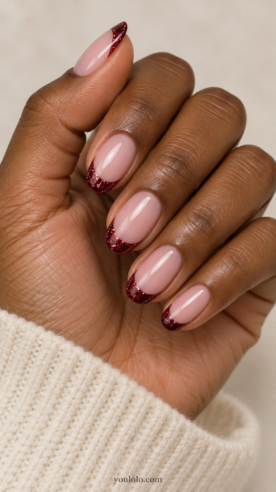 medium oval milky pink nails, ruby microglitter French tips only, smooth sealed finish on a naturally gathered hand